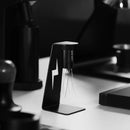Black coffee grounds whisk on a stand with blurred kitchen background