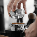Coffee dosing ring being used with a blurred coffee-making background