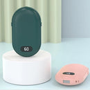 Two portable heating devices, one green and one pink, on a light blue background with text 'Warm in hand, warm in heart, a winter surprise'.