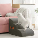 Gray pet ramp with a white dog on top in a living room setting.
