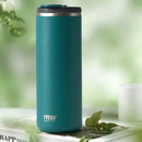 Teal TYESO tumbler on a white surface with greenery in the background